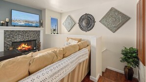 Ein Wohnzimmer mit Kamin, Fernseher und dekorativen Wandbildern.