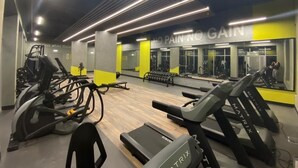 Et fitnessrum med løbebånd, crosstrainere og vægtbænke.