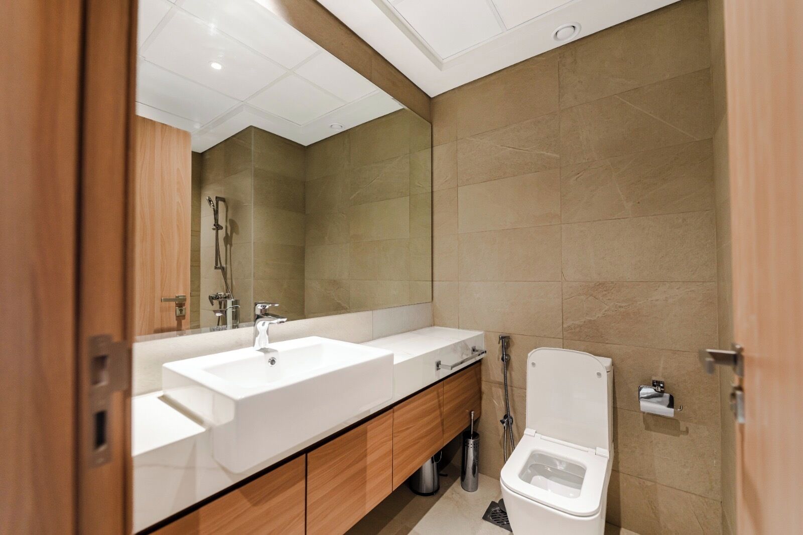 A modern bathroom with two sinks, a toilet, and a shower.