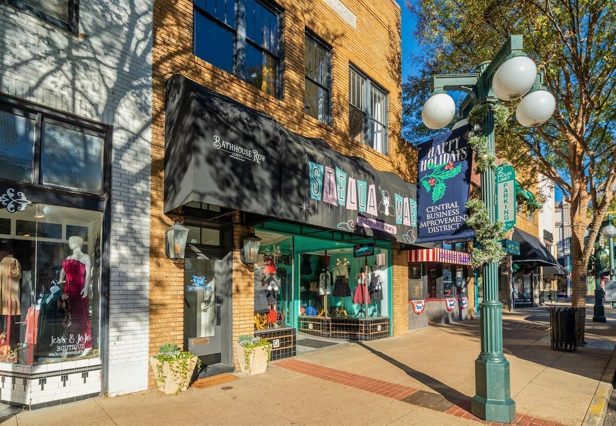 Une devanture de magasin avec une enseigne indiquant « Bathhouse Row » et « Quartier central des affaires – joyeuses fêtes ».