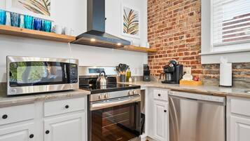 Una cocina moderna con estufa, microondas y lavavajillas de acero inoxidable.