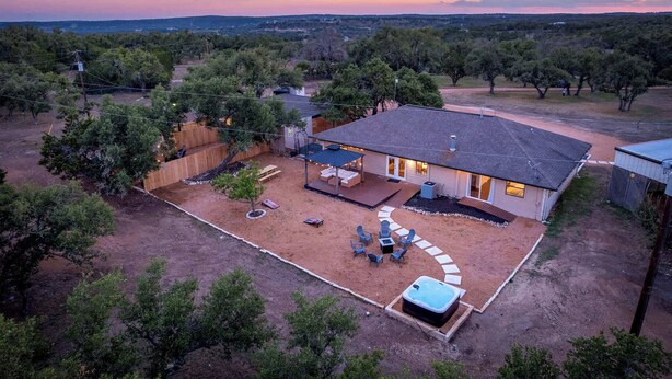 A house with a patio, outdoor seating, and a hot tub. - 6 BR Private Ranch, 2 Hot Tubs, Game Barn (Fredericksburg)
