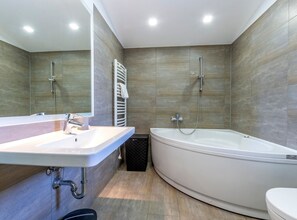 A modern bathroom with a white sink, a bathtub, and a shower. - Serene Rural Villa with Pool, Sun Deck, and Children's Play Area - Five Bedroom Villa (Tugare)