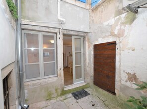 Cozy space with a metal door, wooden door, and metal grate.