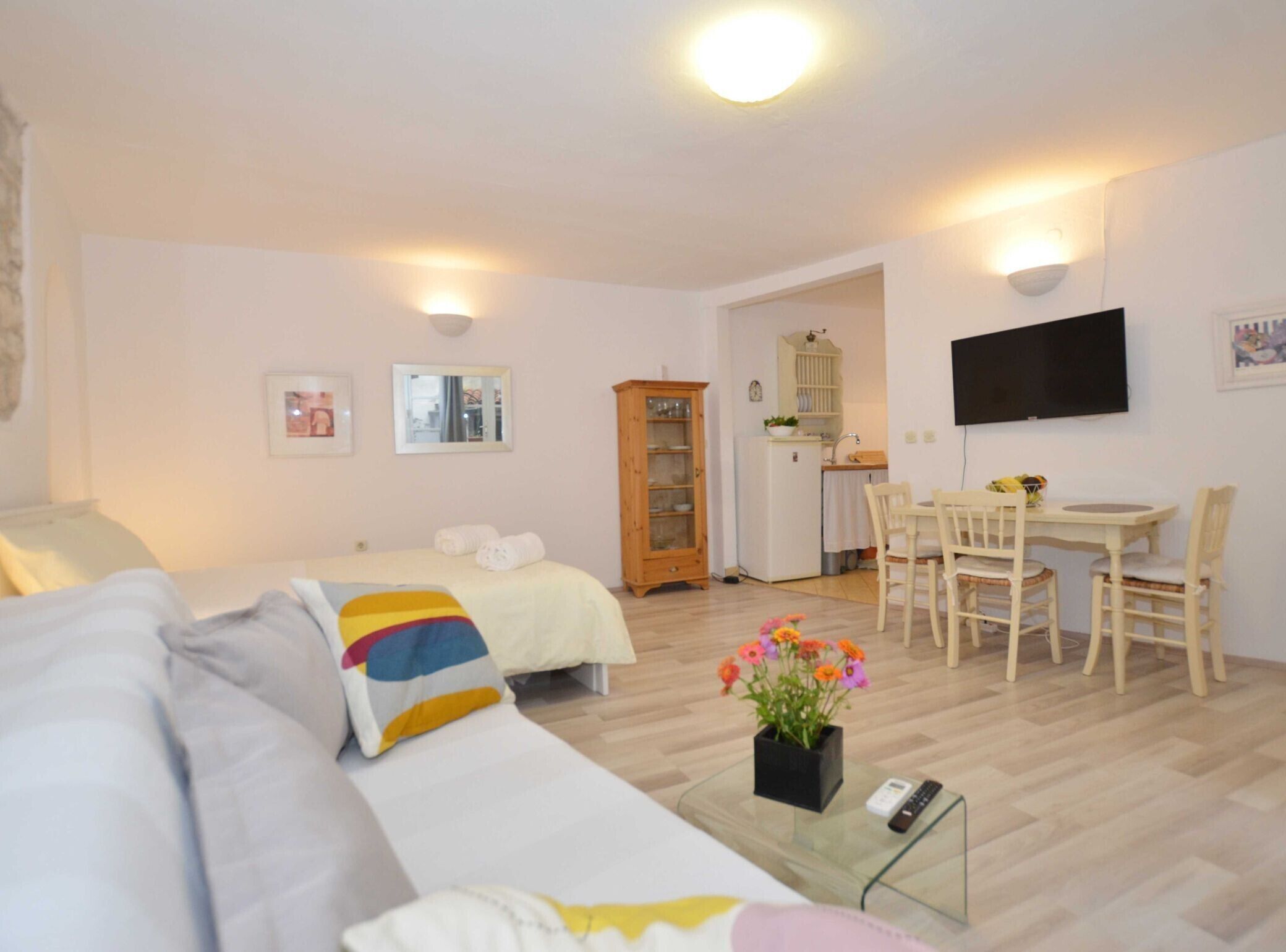Une chambre d’hôtel confortable avec deux lits, un coin repas et une télévision.