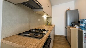 A modern kitchen with a gas stove, wooden countertop, stainless steel appliances, and a water dispenser. - Rovinj Countryside Escape Holiday Home - Two Bedroom Holiday Home with Terrace (Rovinj)