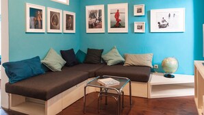 Ein modernes Wohnzimmer mit einer Eckcouch, einem Glastisch und einem Globus auf einem Beistelltisch.