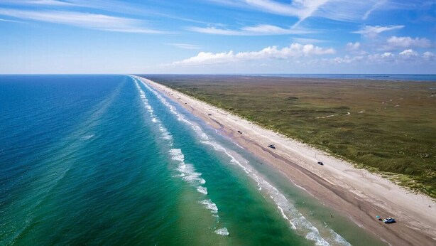 An aerial view of a beach with a long stretch of sand and ocean. - Walk to Beach~Heated Pool~BBQ Area~Balcony~Island (Corpus Christi)