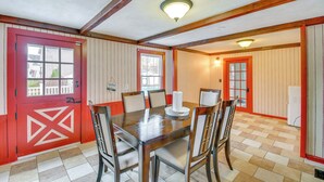 A dining area with a wooden table and chairs, a red door, and a white refrigerator. - 5 Mi to Lake Ontario: Mexico Home w/ Seasonal Pool (Mexico)