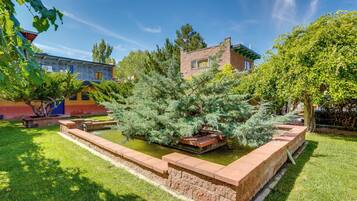 A courtyard with a water feature, a brick building, and surrounding greenery.