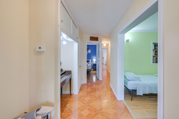 Un couloir donnant sur une chambre avec un lit, un bureau et une salle de bain.