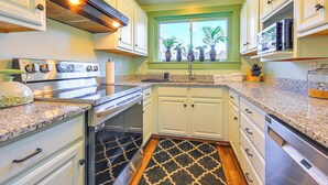 A kitchen with white cabinets, granite countertops, a stainless steel range, and a black and white patterned rug. - 18 Mi to Skiing: Colorful Home in Springfield! (Springfield)