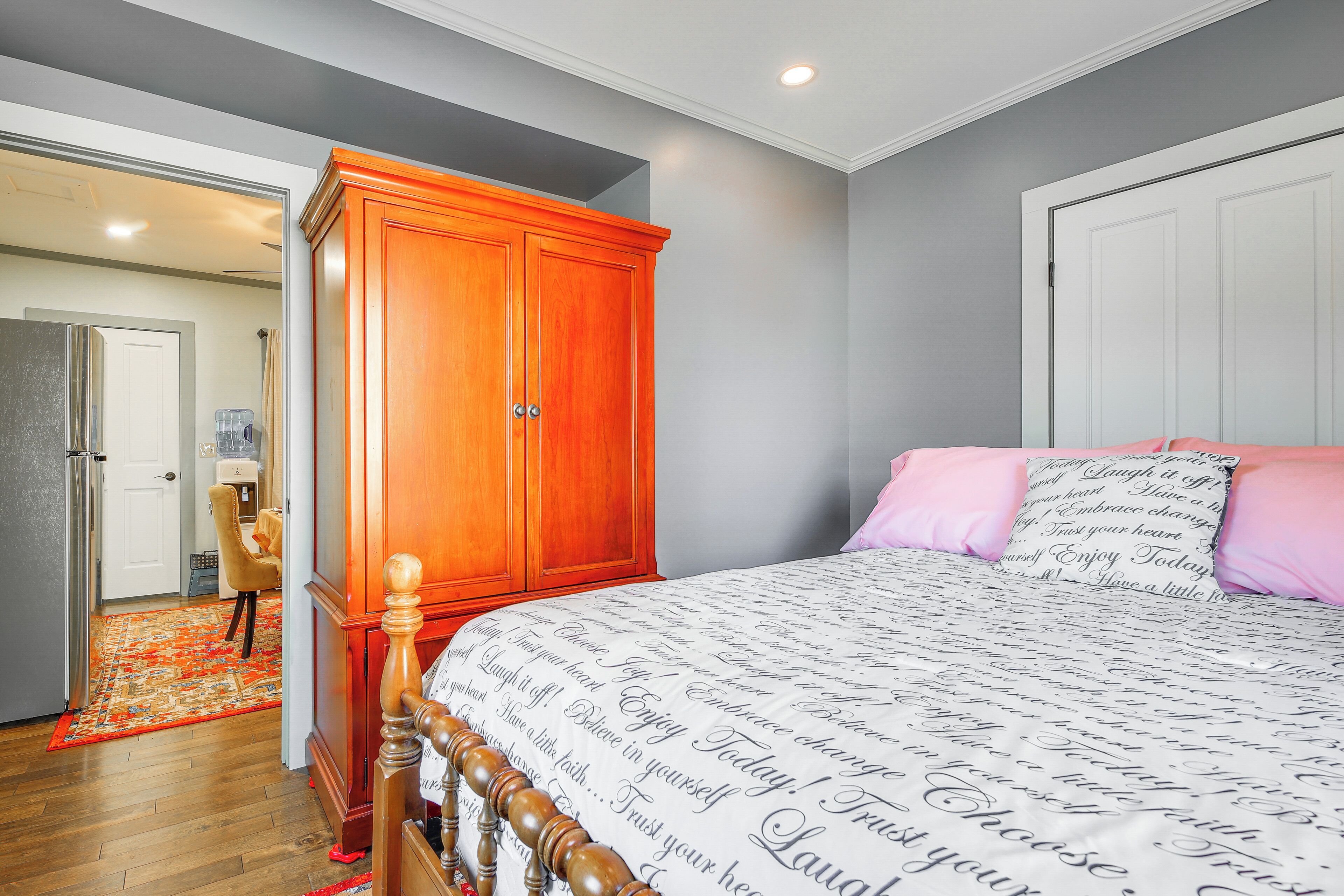 A bedroom with a bed, a wardrobe, and a bathroom visible through an open door.