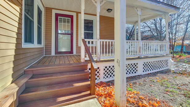 A wooden house with a porch, a red door, and a staircase leading to the entrance. - 18 Mi to Skiing: Colorful Home in Springfield! (Springfield)