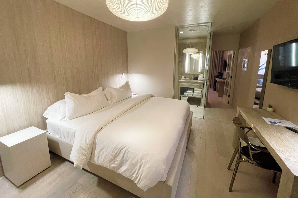 Une chambre d’hôtel moderne équipée d’un lit, d’un bureau et d’une télévision.