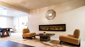 A modern living room with a fireplace, two armchairs, a coffee table, and a rug. - Palace Modern Hotel at the Plaza (Santa Fe)
