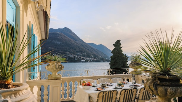 A terrace with a table set for dining, overlooking a lake and mountains. - La Casa - Spacious apartment in historic villa with private lake access (Carate Urio)