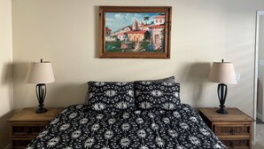 A bedroom with a bed, two nightstands, two lamps, and a framed painting on the wall. - Charming 1-bedroom Casita in gated Duna La Quinta. Walk to Old Town & LQ Resort (La Quinta)