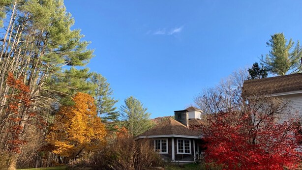 A house with a chimney, surrounded by trees with autumn foliage. - UU Rowe Camp and Conference Center (Rowe)
