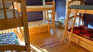 A bunk bed room with a desk and chair, wooden floors, and a window. - UU Rowe Camp and Conference Center (Rowe)
