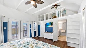 A bedroom with a bed, a wardrobe, a vanity, and a balcony.