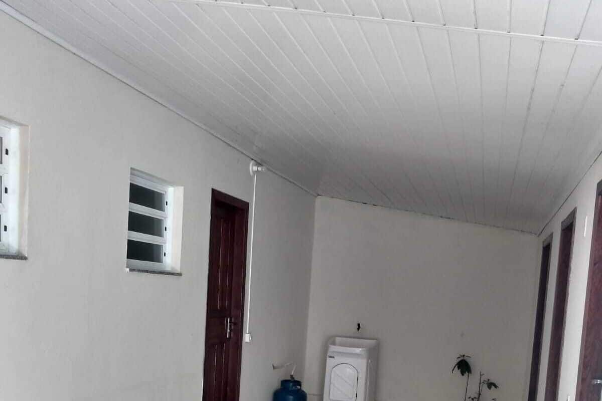 Ein geräumiges Zimmer mit Fliesenboden, weißer Decke und einer Tür.