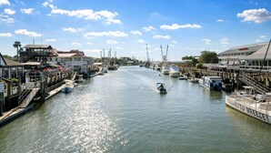 Un port de plaisance avec des bateaux amarrés, une jetée avec un restaurant et un bâtiment portant une enseigne.