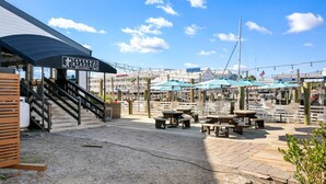 Un restaurant situé au bord de l’eau, doté d’une terrasse, d’une entrée couverte et offrant une vue sur l’eau.