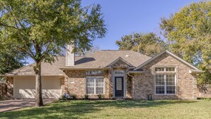 A two-story house with a brick exterior, a front garage, and a well-maintained lawn. - Augusta: 1 Mile from Texas A&M/Near Sorority Row (College Station)