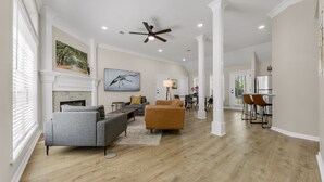 A spacious living room with hardwood flooring, a fireplace, and a ceiling fan. - Augusta: 1 Mile from Texas A&M/Near Sorority Row (College Station)