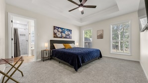 A bedroom with a bed, a ceiling fan, a window, and a shower area. - Augusta: 1 Mile from Texas A&M/Near Sorority Row (College Station)