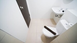 Um banheiro pequeno com vaso sanitário, pia e porta.