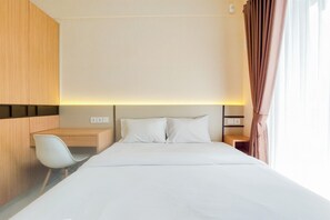Una camera d'albergo con un letto, una scrivania, una sedia e un comodino.
