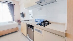 A modern kitchen with a built-in dishwasher, a gas stove, and a sink. - Well Furnished And Nice Studio Sky House Bsd Apartment (Pagedangan)