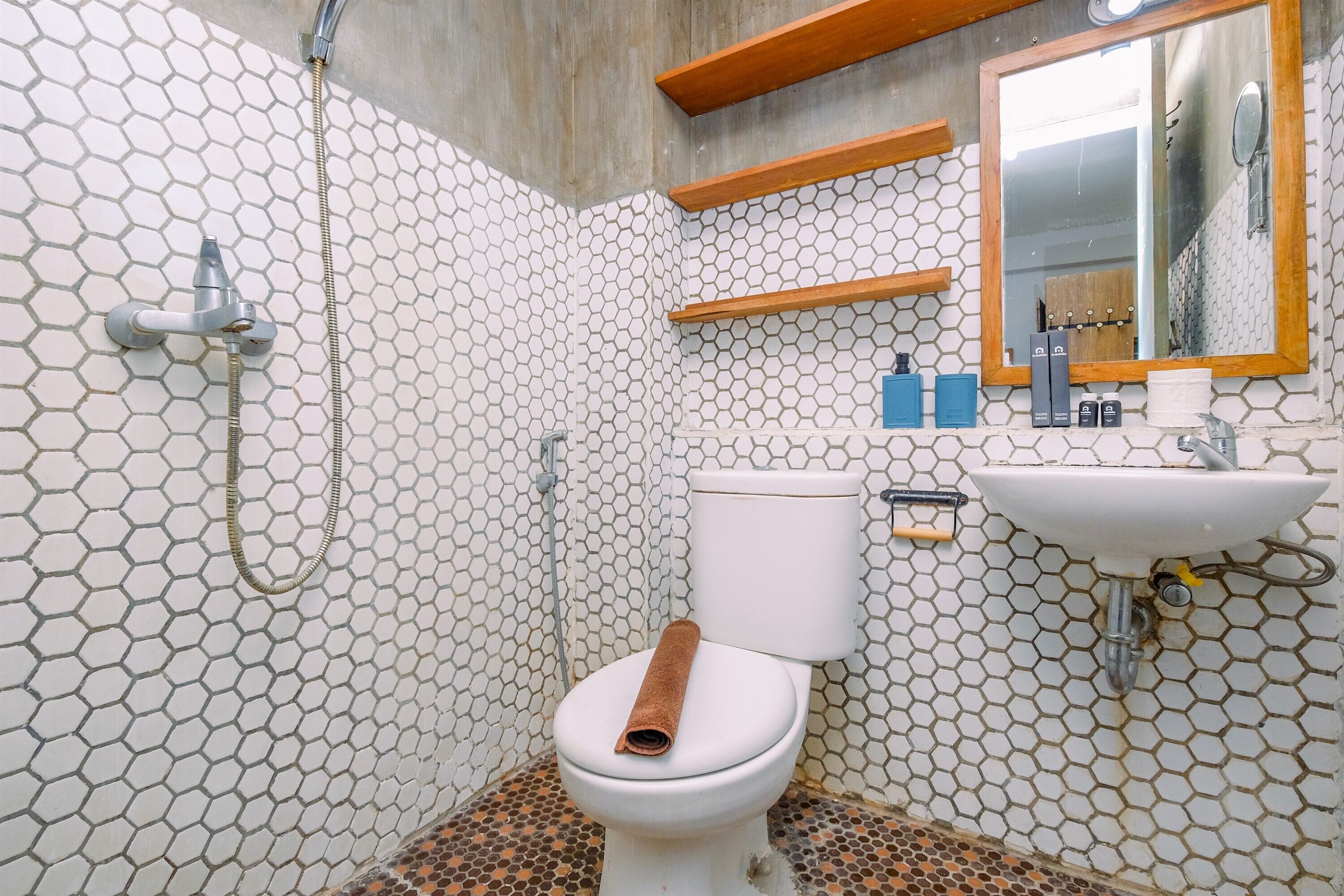 Un baño con un diseño de azulejos hexagonales, un inodoro, un lavabo y un espejo.