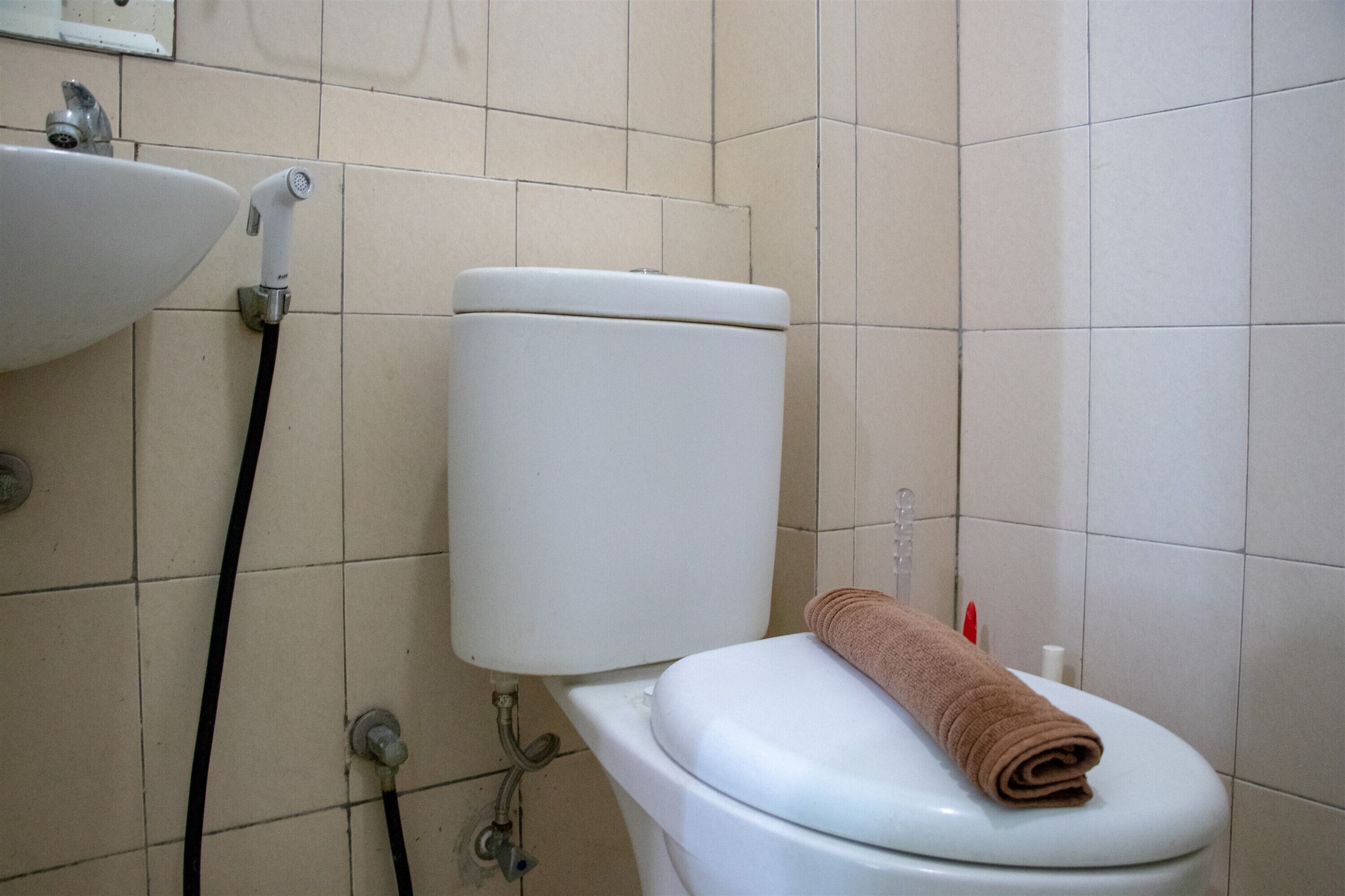 Een badkamer met toilet, wastafel en douche.