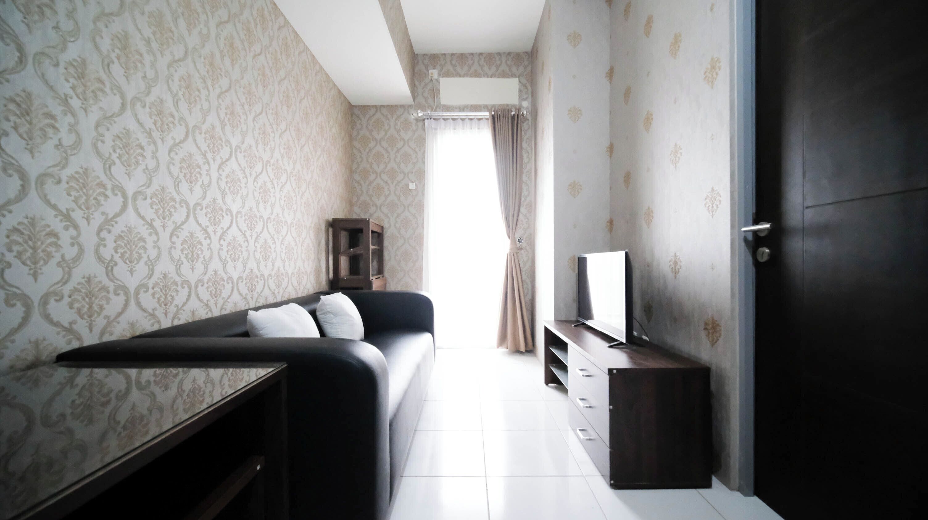 Una sala de estar moderna con un sofá, televisión y un mueble.