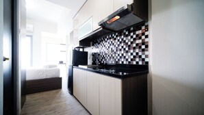 Eine moderne Küche mit schwarzem Arbeitsplatz, einer gefliesten Rückwand und einem eingebauten Backofen.