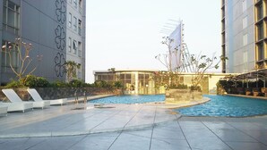 Ein Poolbereich mit Liegestühlen und einem Gebäude mit einer markanten Fassade.