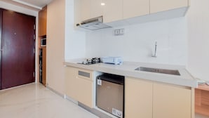 A modern kitchen with a built-in dishwasher, a microwave, and a gas stove. - Well Design And Comfy Studio Sky House Bsd Apartment (Pagedangan)