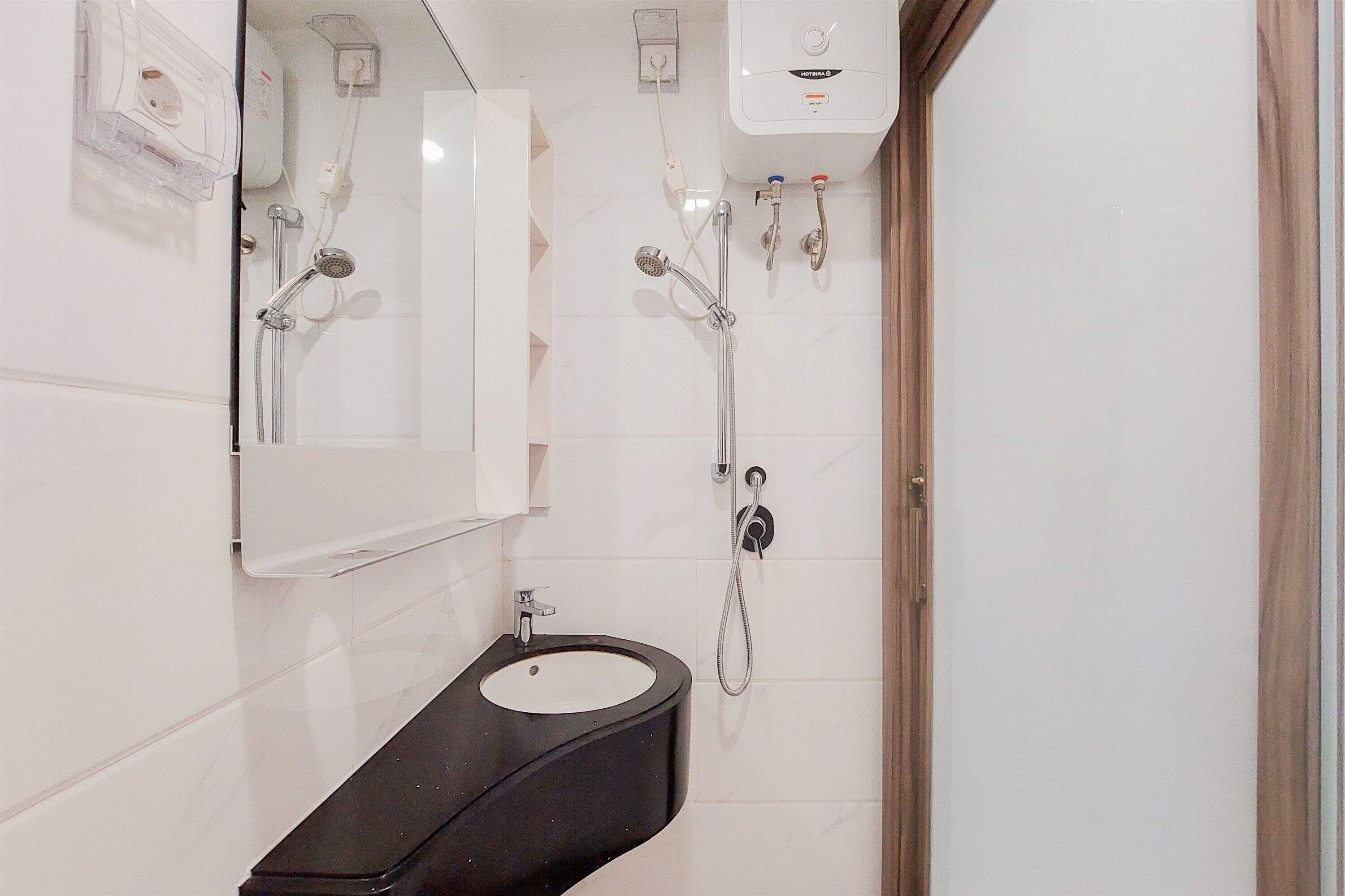 A bathroom with a sink, mirror, and shower.