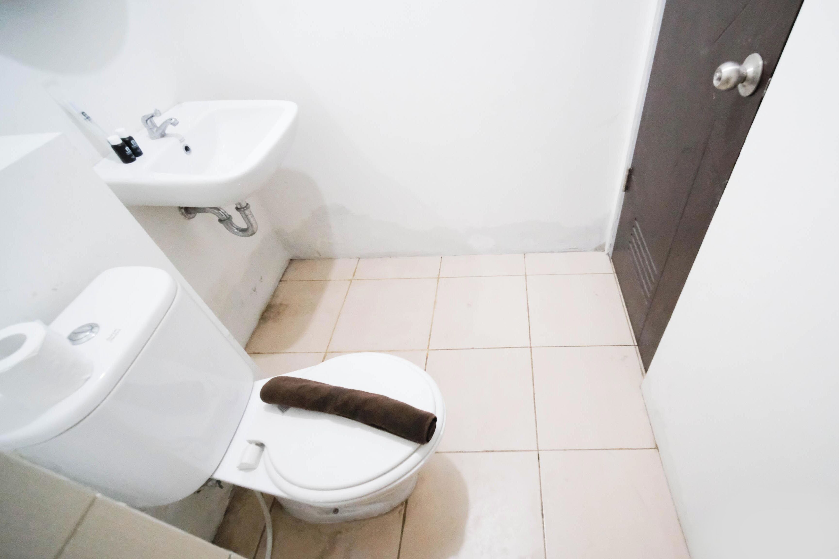 Ein kleines Badezimmer mit Toilette, Waschbecken und einer Tür.