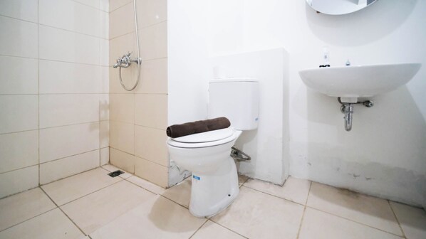 Un baño con inodoro, ducha y lavabo.