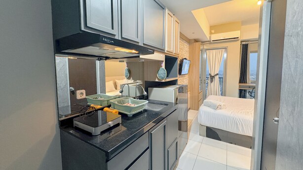 Una cucina funzionale con elettrodomestici moderni, un piccolo angolo ristoro e una camera da letto con vista.
