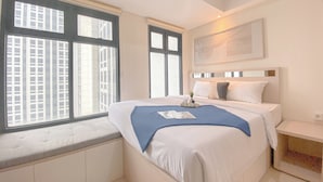 A hotel room with a large bed, a bench at the window, and a painting on the wall. - Comfortable 1Br Apartment At Pollux Chadstone (Cikarang)