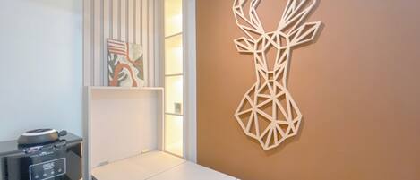 A modern room with a white wall, a geometric deer sculpture, and a water dispenser.