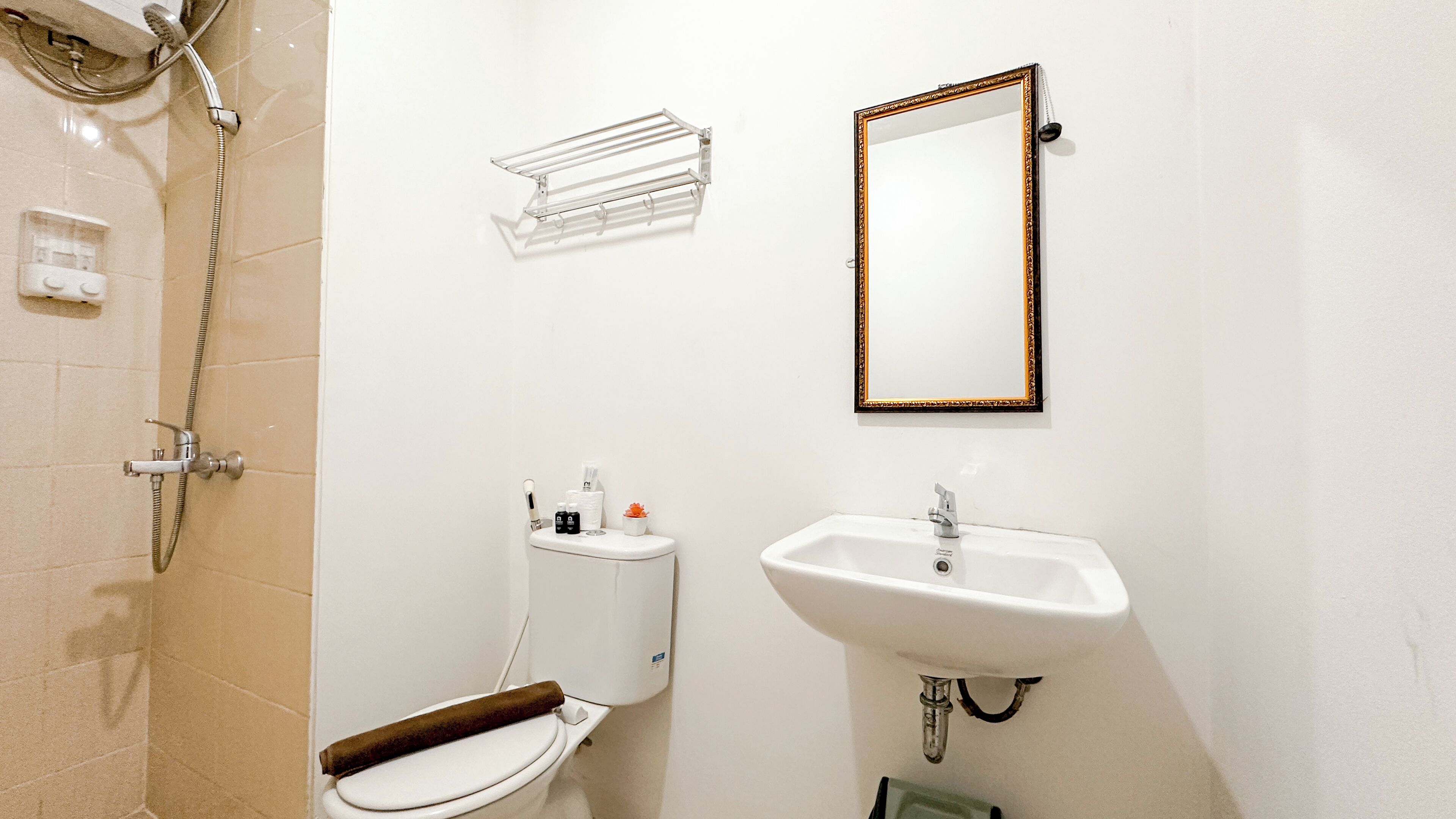 Une salle de bain comprenant des toilettes, un lavabo, une douche et un miroir.