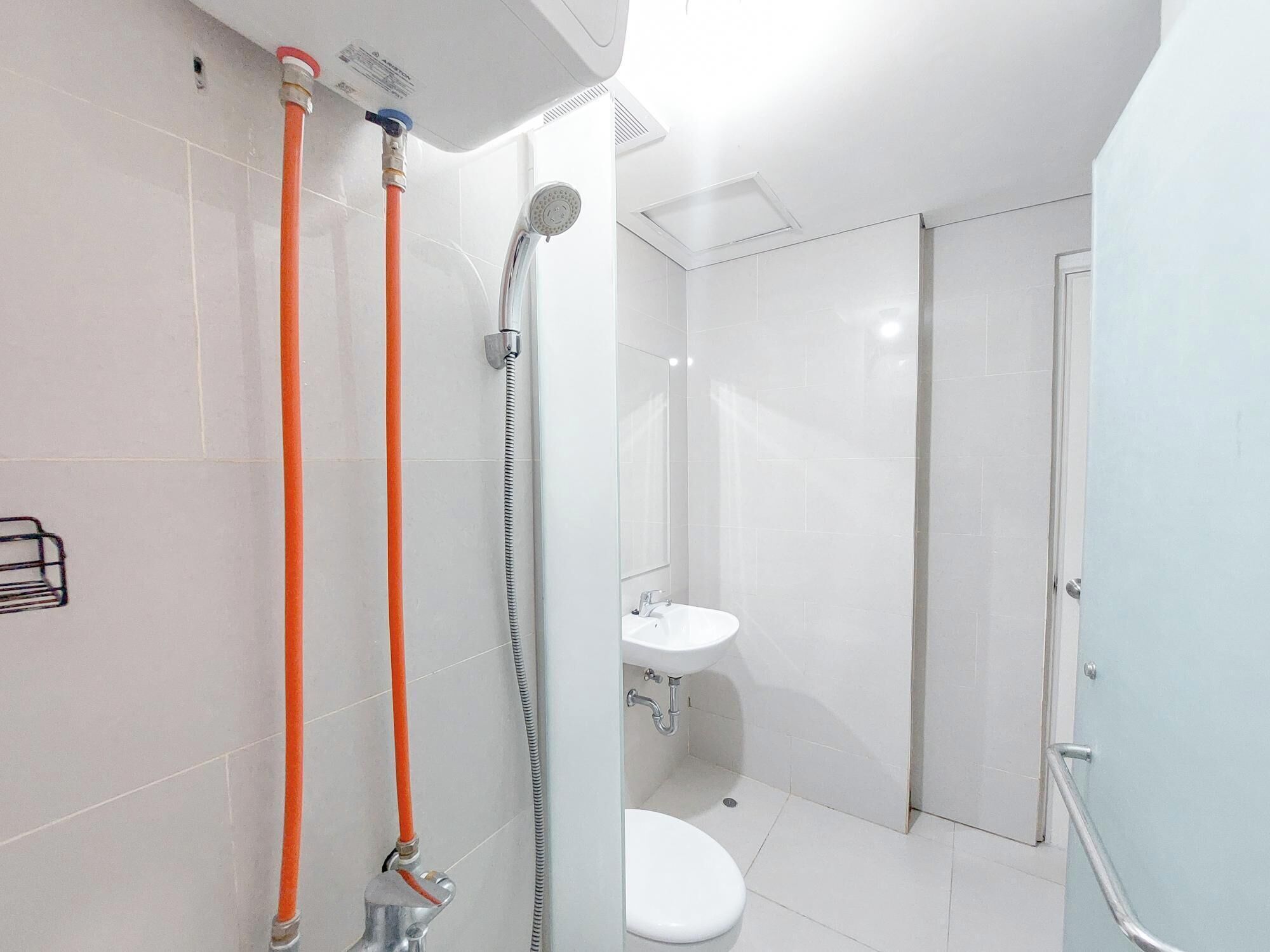 A modern bathroom with a shower, toilet, and sink.