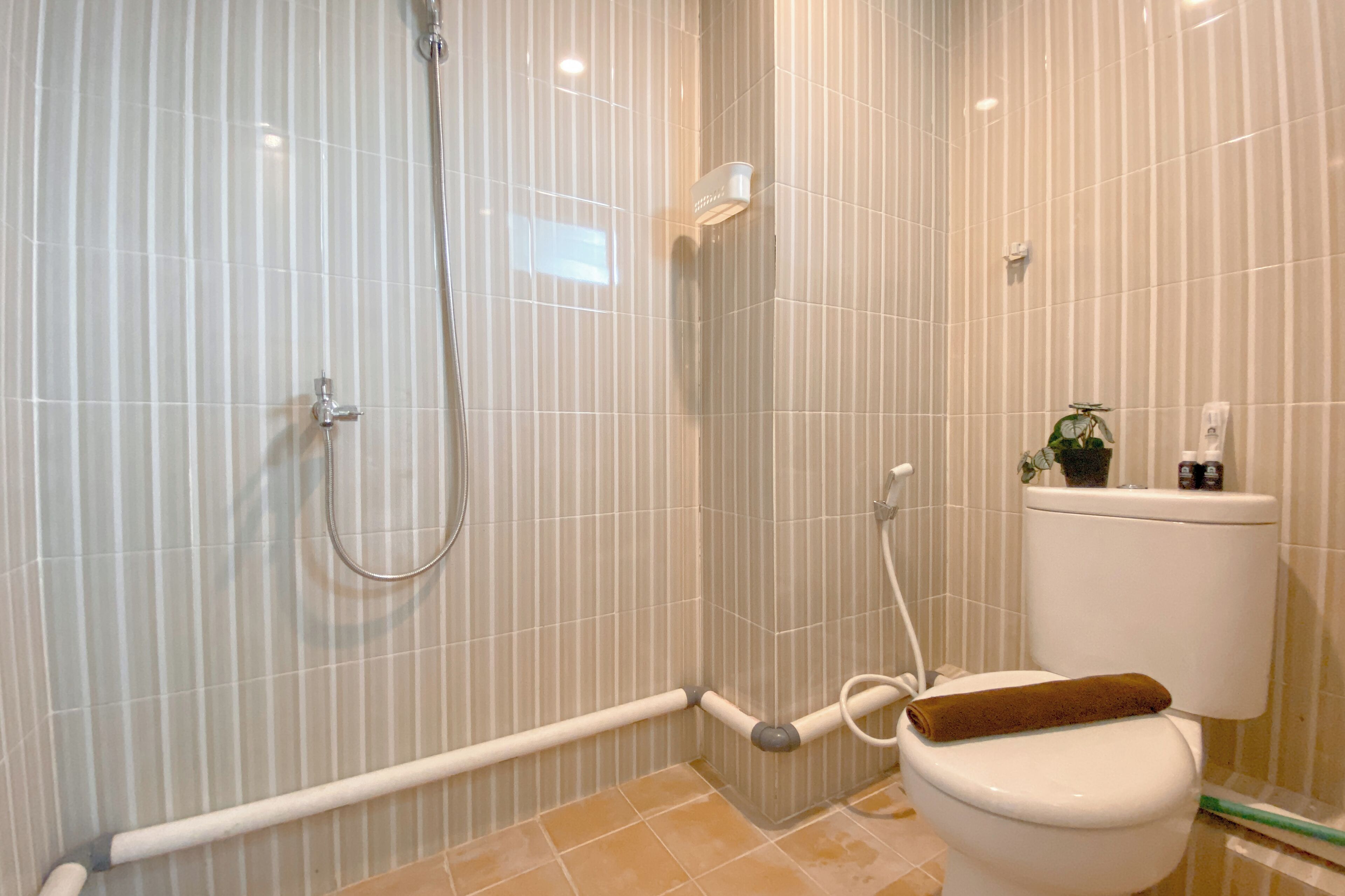 A bathroom with a shower, toilet, and a towel rack.