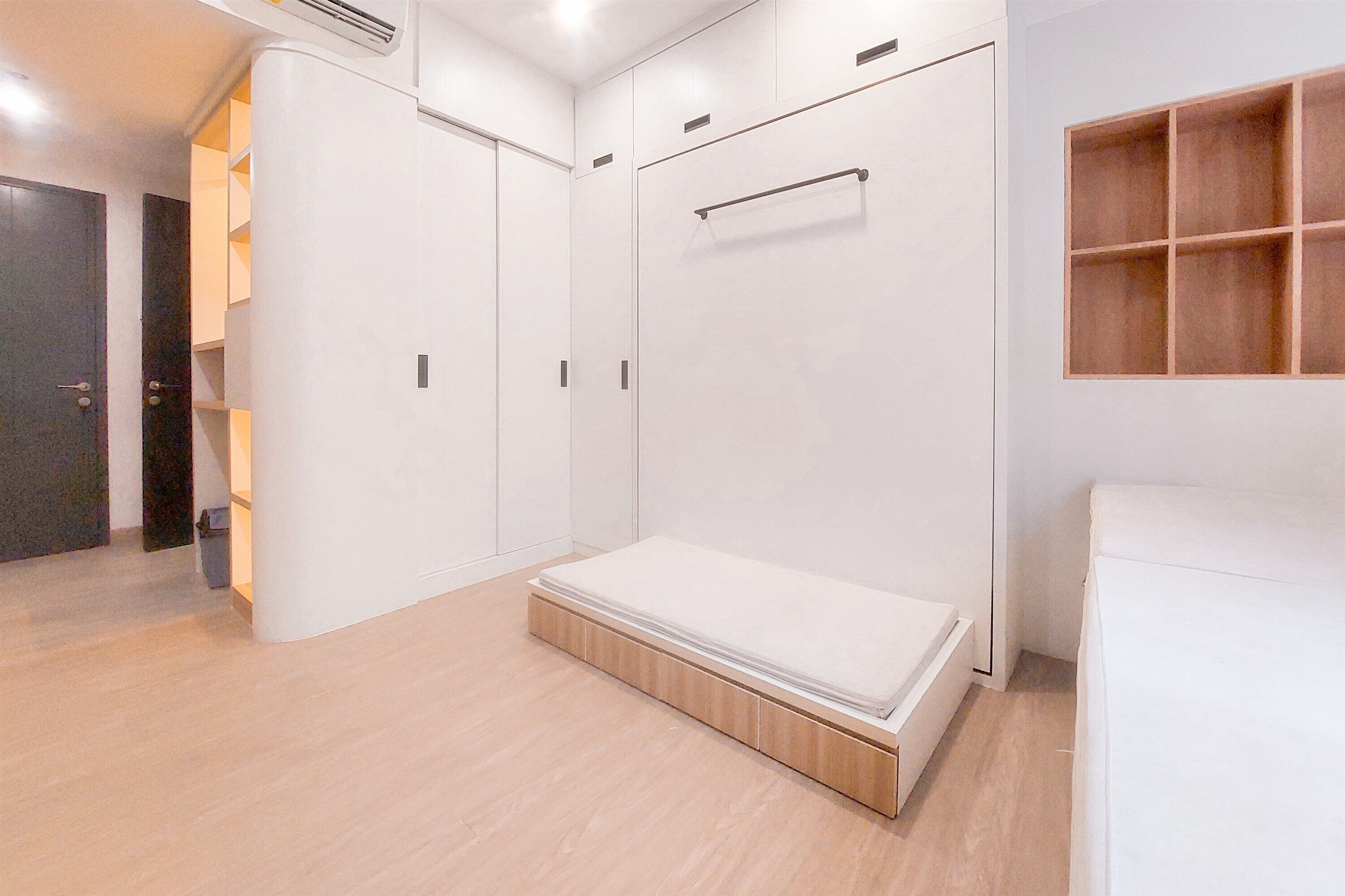 A bedroom with a bed, wardrobe, and built-in shelving.